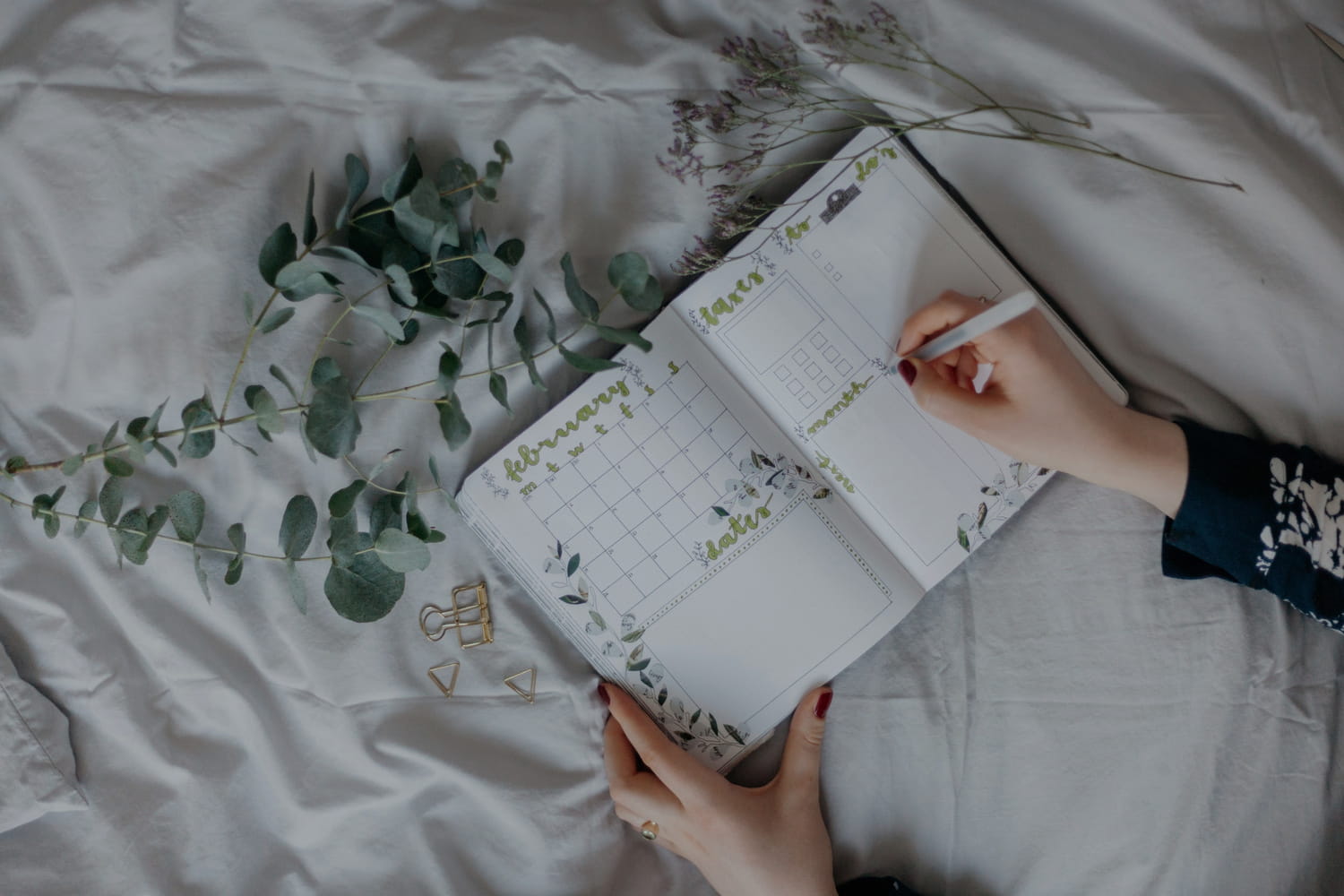 A pretty bullet journal being written on by a woman.